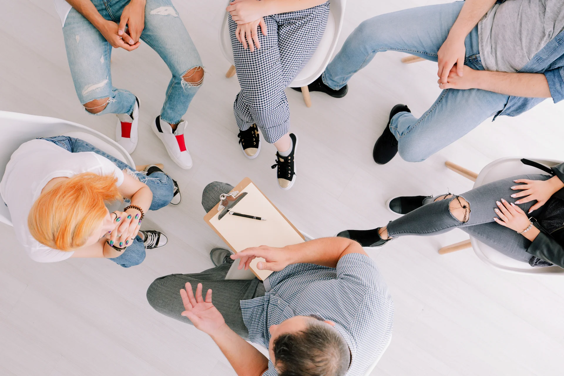 A group therapy circle with a facilitator leading a CBT