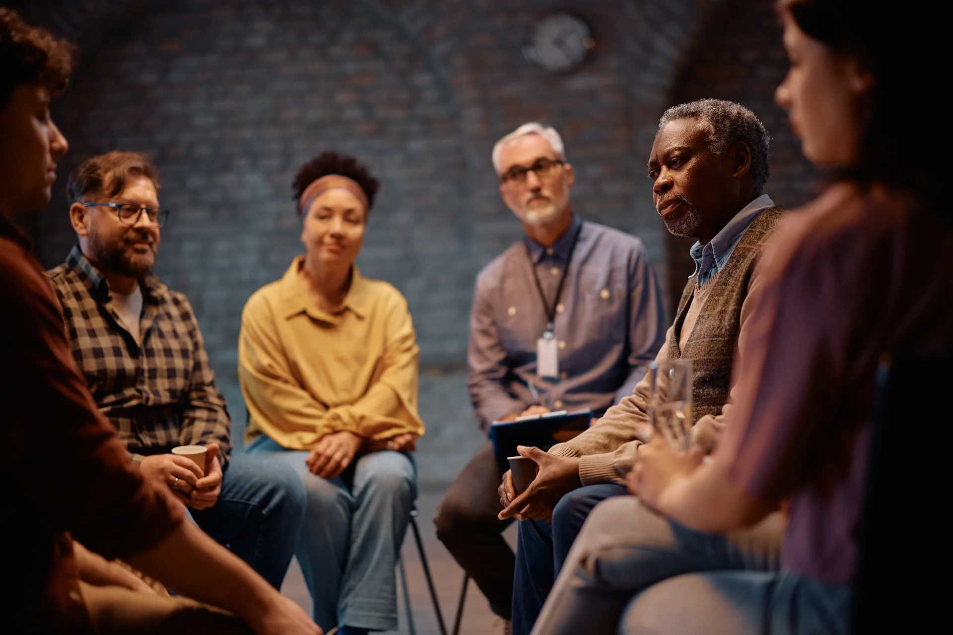 A diverse group of individuals sitting in a circle during therapy