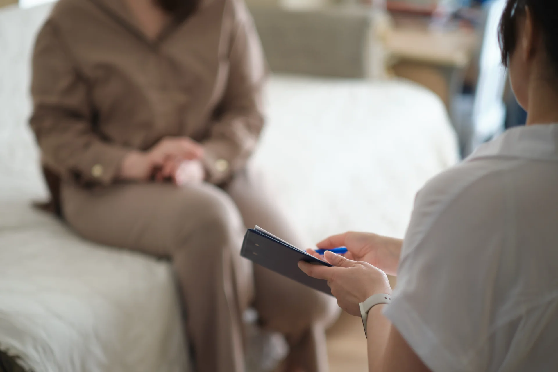 A therapist leading a CBT-focused session with patients taking notes