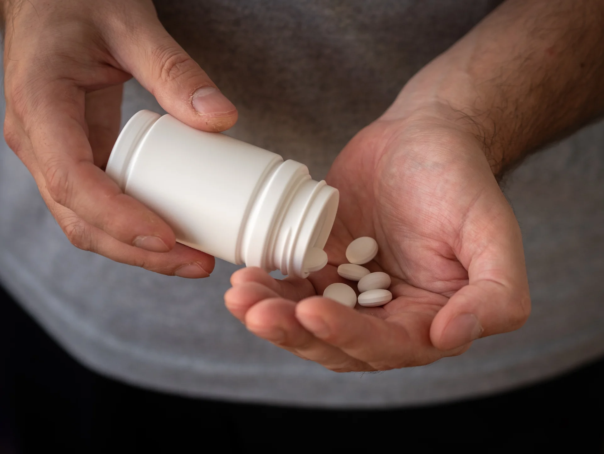Man putting pills on his hand
