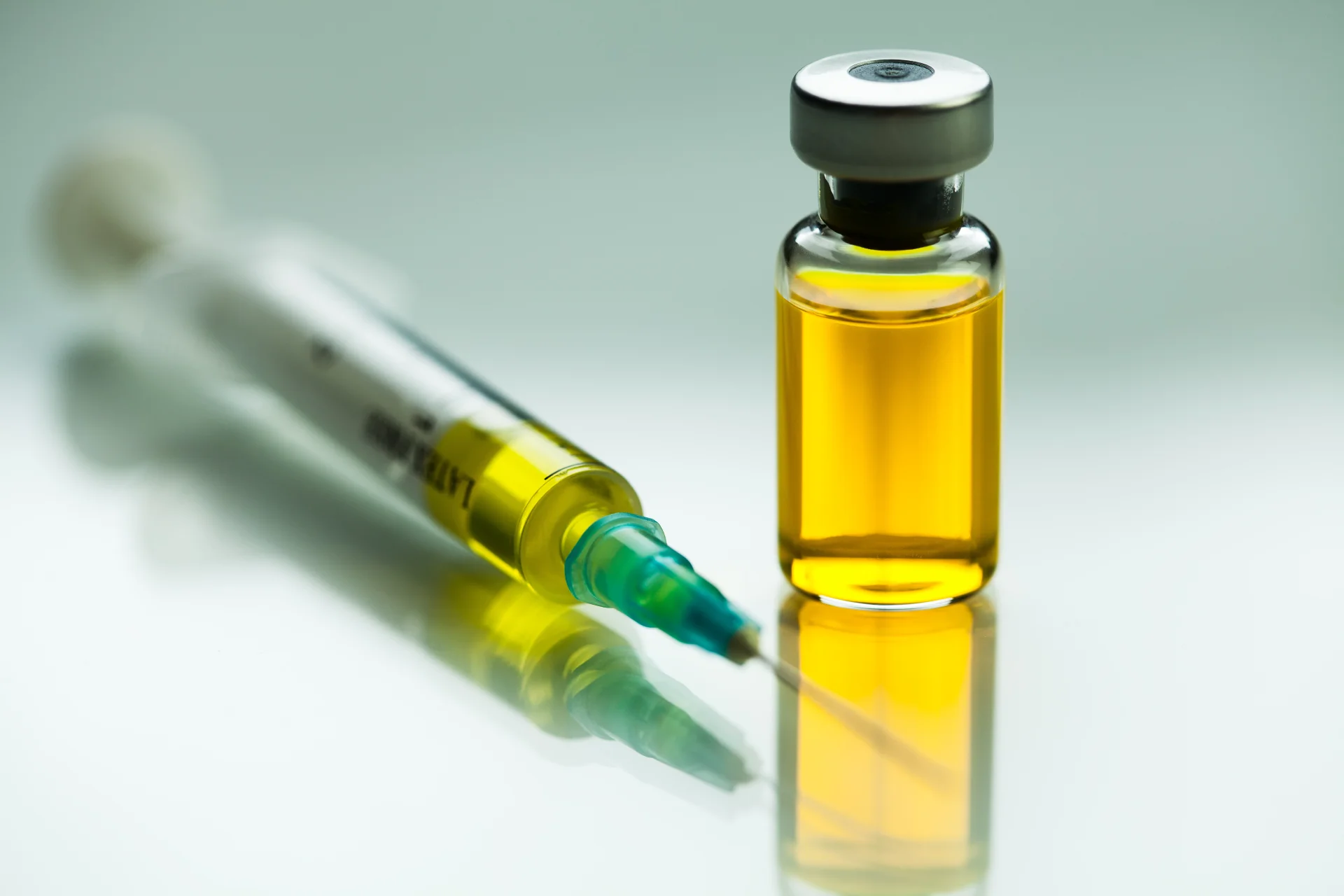 Syringe with needle and vial ampoule with yellow liquid