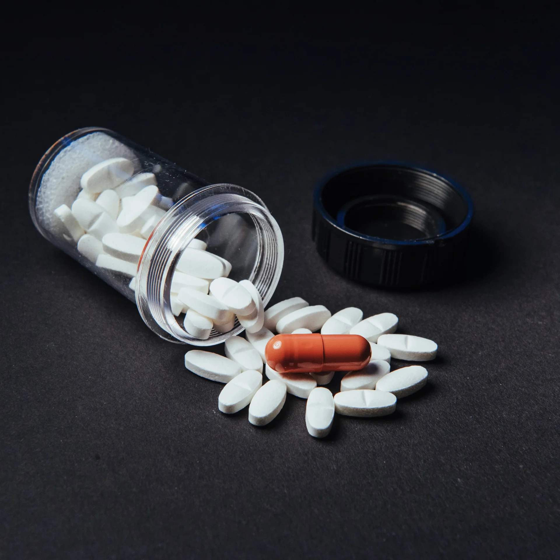 Pill jar, pills scattered on the table spilling out of the jar