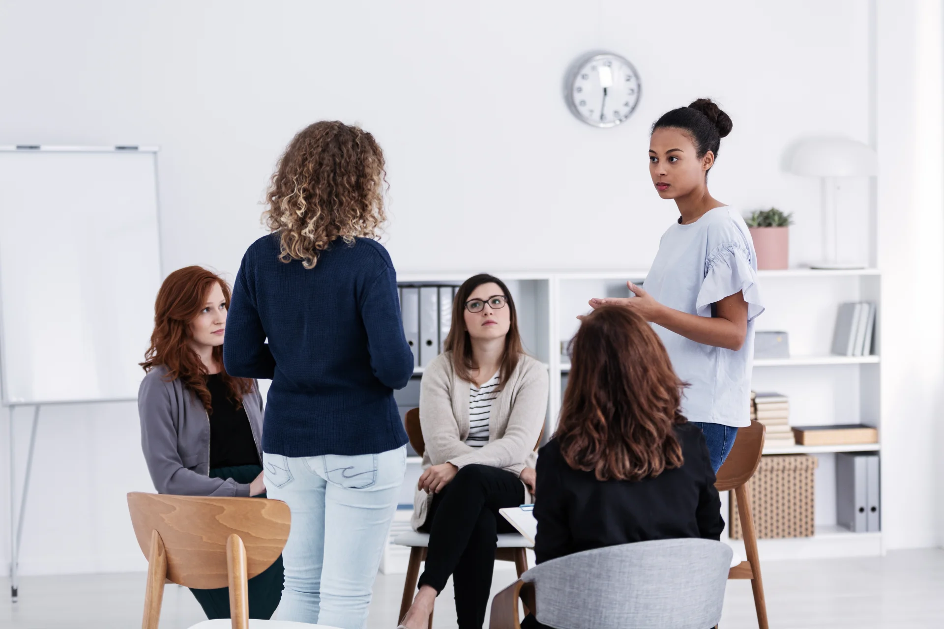 Diverse group of women in a circle in a sunlit community room