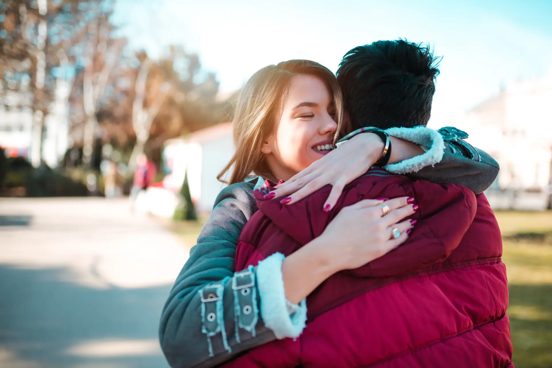 A person leaving a treatment center and hugging a supportive family member, symbolizing transition from rehab into the next stage of recovery.
