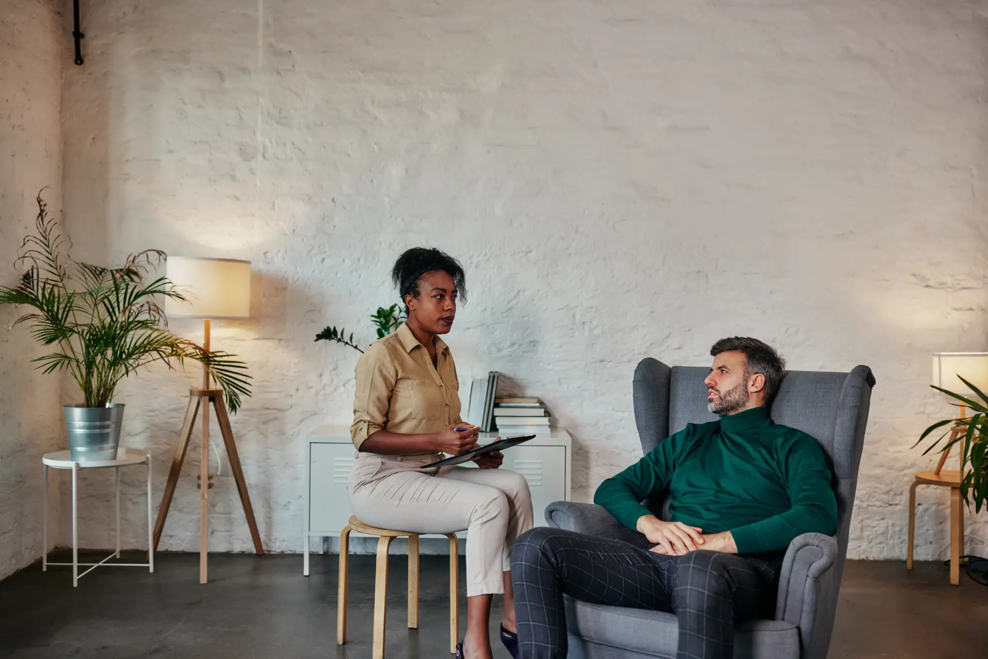 Calm, well lit counseling room with two chairs and a small table, suggesting safety and professional support.