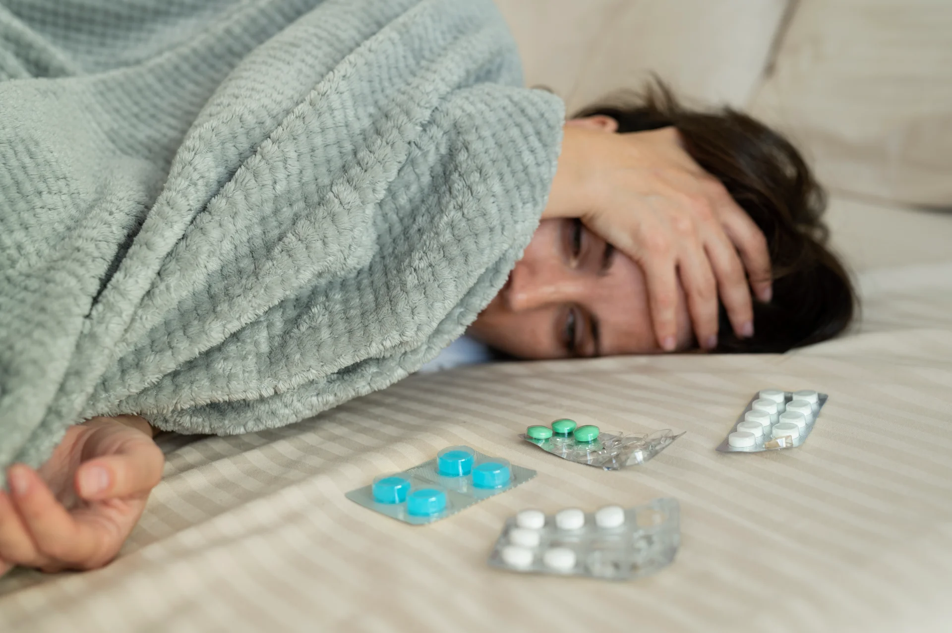 woman with pills in bed